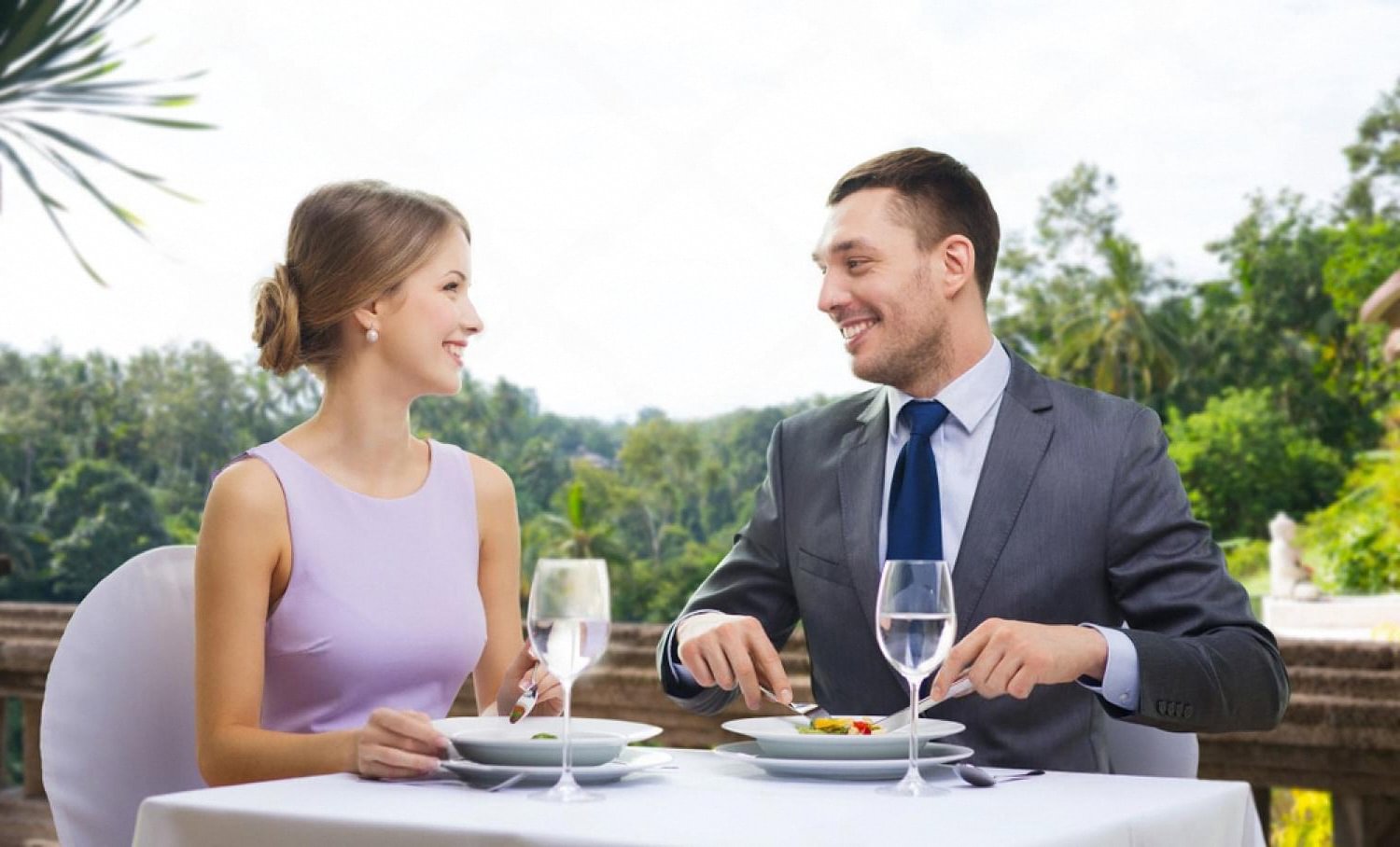 Couple enjoying a fine dining meal at a hotel restaurant terrace during a US holiday